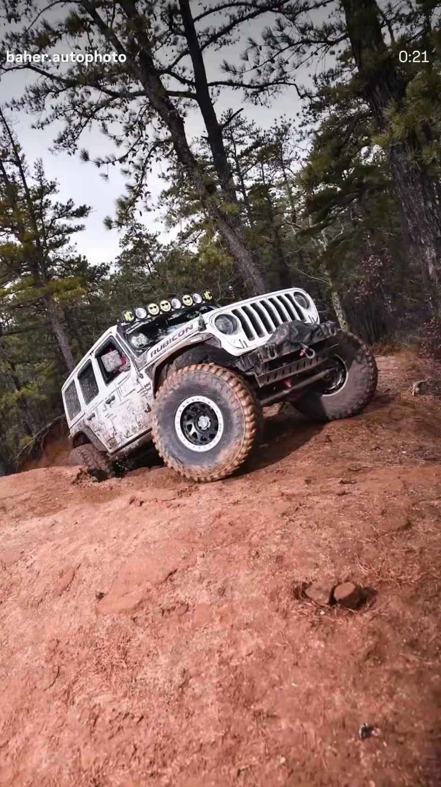 White Jeep Rubicon climbing a trail with 37s